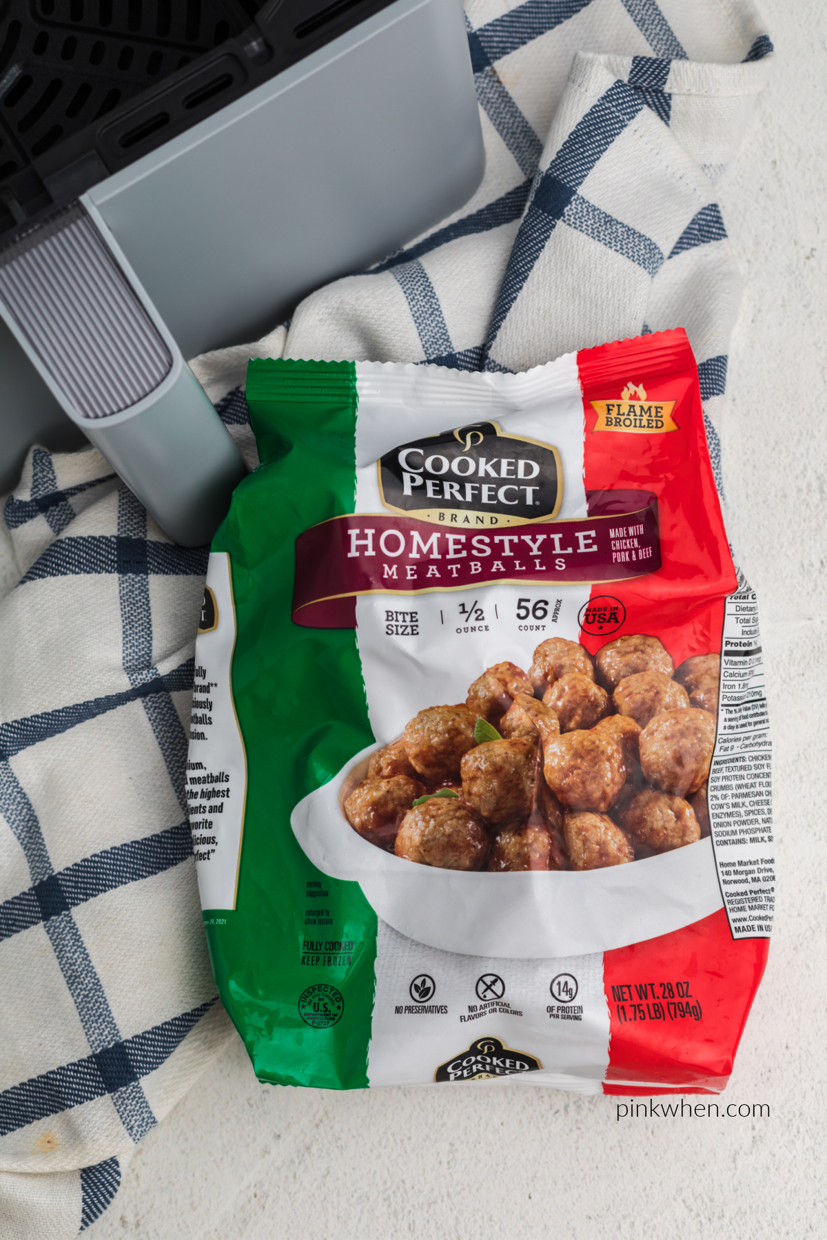 Air fryer basket and a bag of frozen meatballs ready to be cooked in the air fryer.
