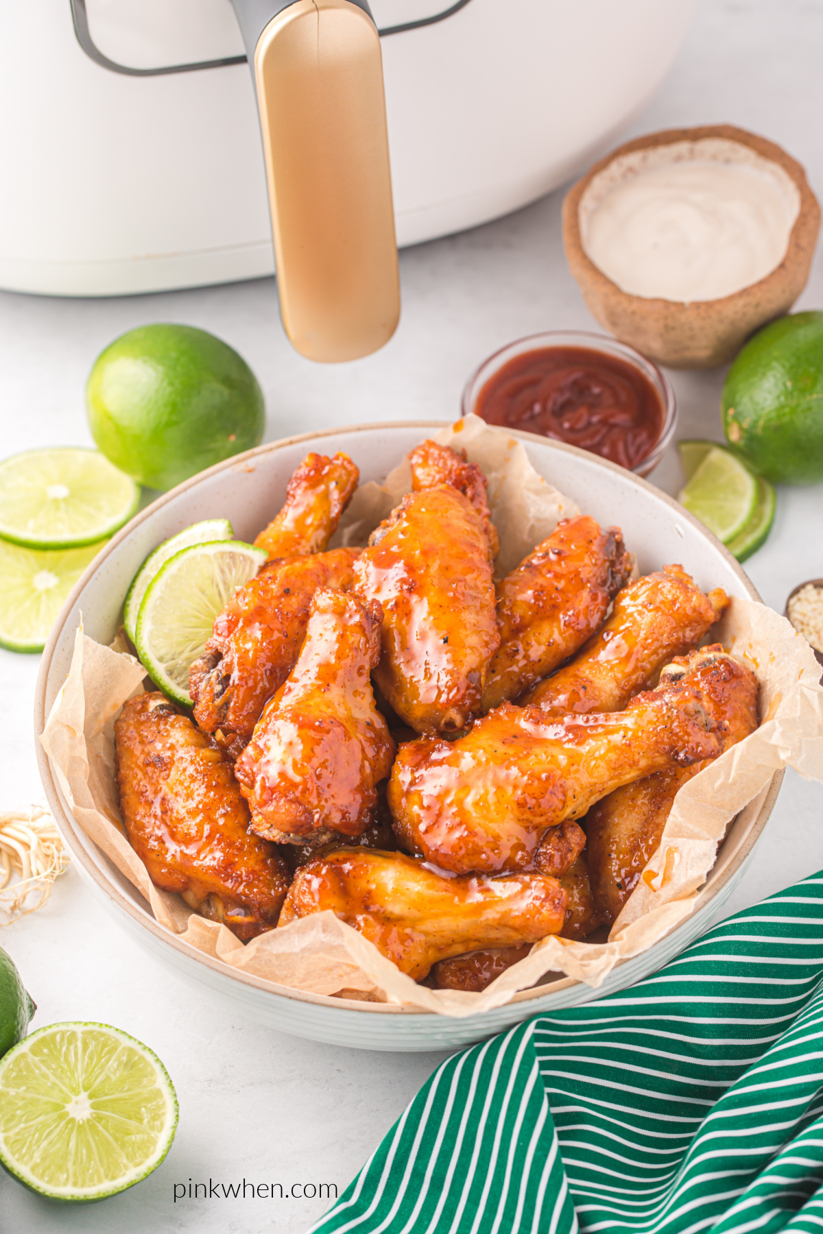 Basket of air fryer chicken wings made with honey sriracha sauce. 