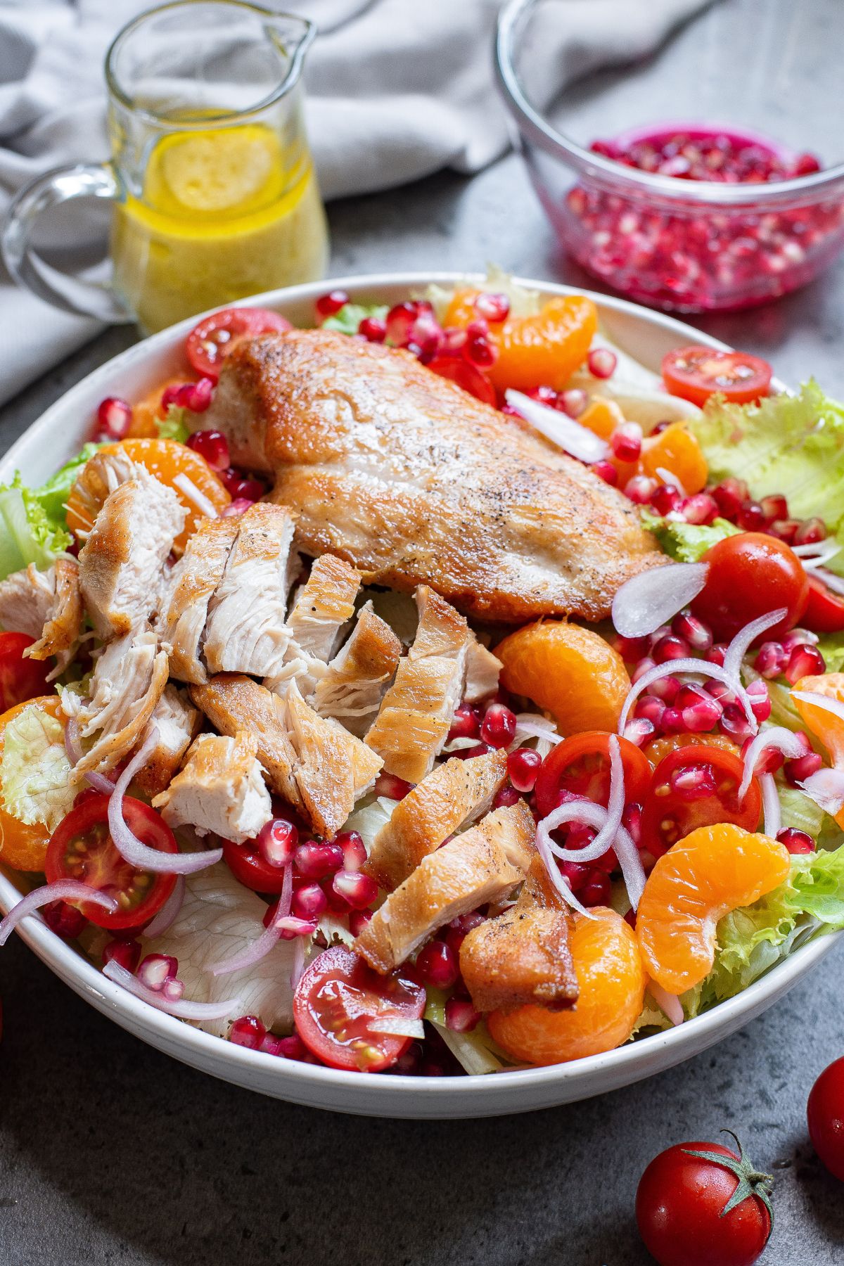 Cooked chicken on top of a salad, being cut into slices. 