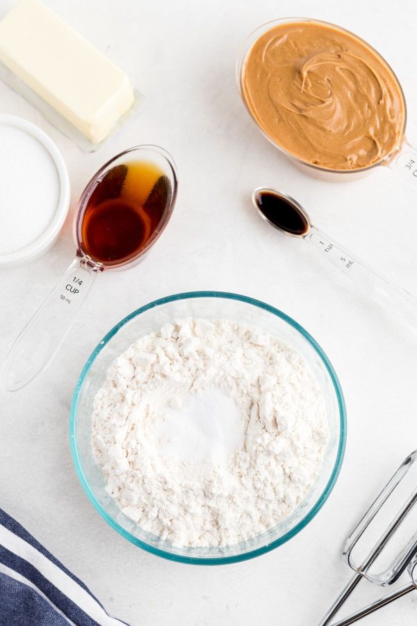 Ingredients needed to make peanut butter cookies without brown sugar measured and on a white marble table. 