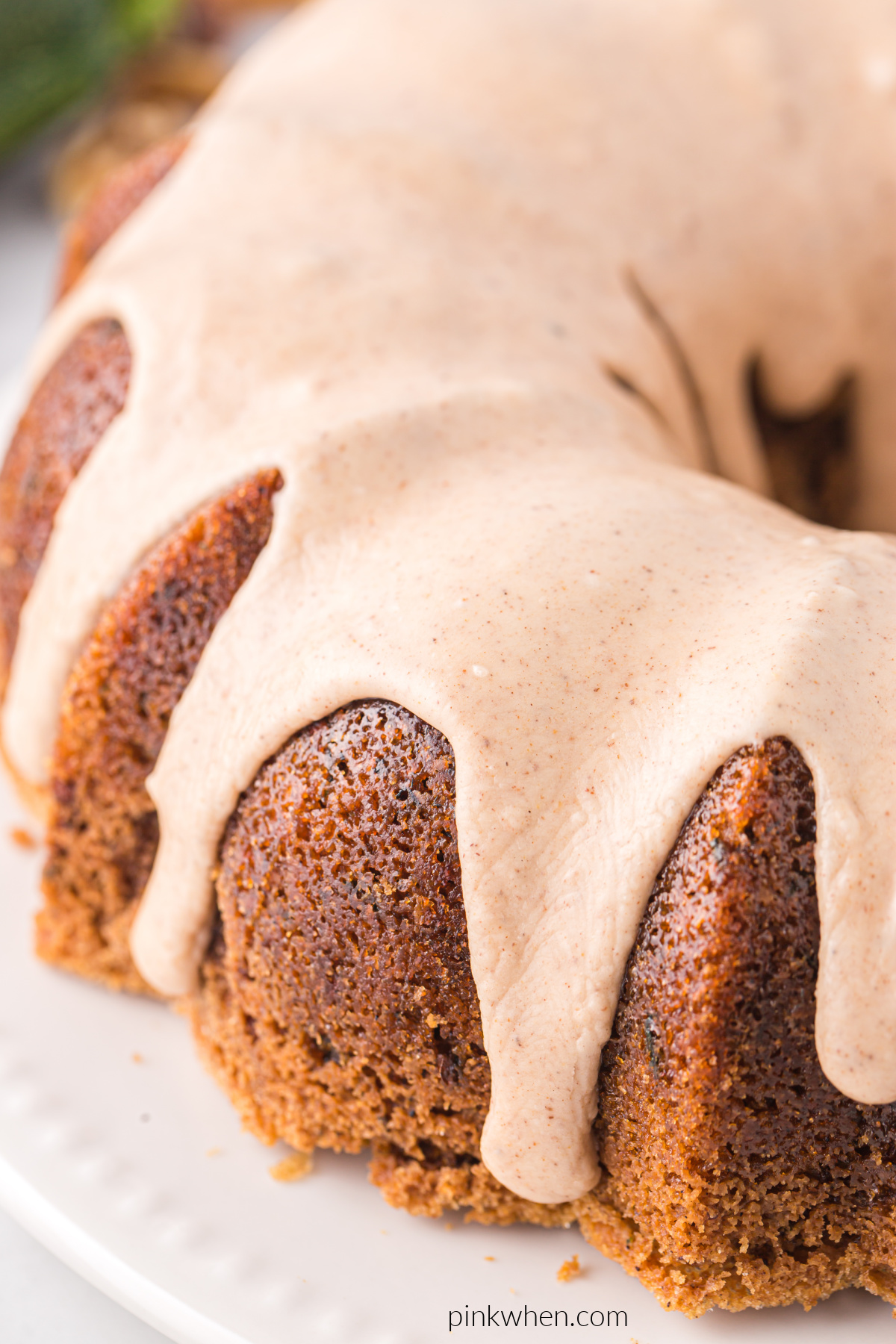 Close up photo of zucchini bundt cake topped with cinnamon icing.