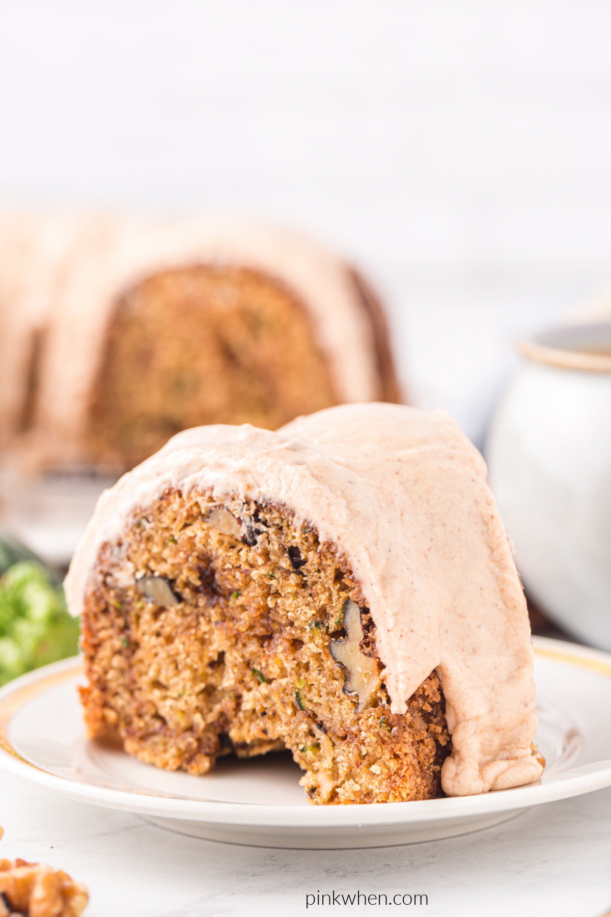 Sliced zucchini bundt cake with cinnamon icing on a plate and ready to serve.
