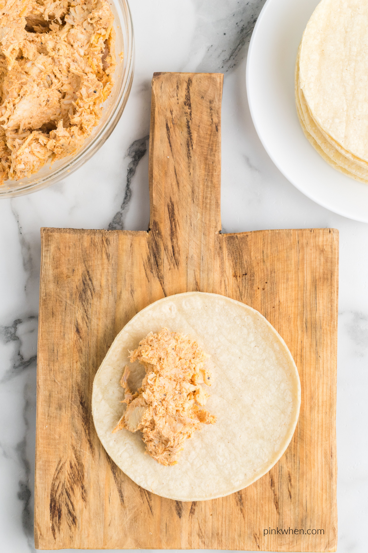 Chicken and cheese mixture added to the tortilla.