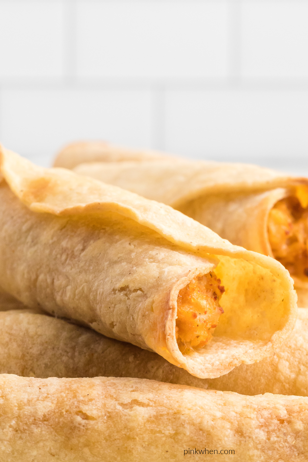 Close up of chicken taquitos stacked and ready to eat.