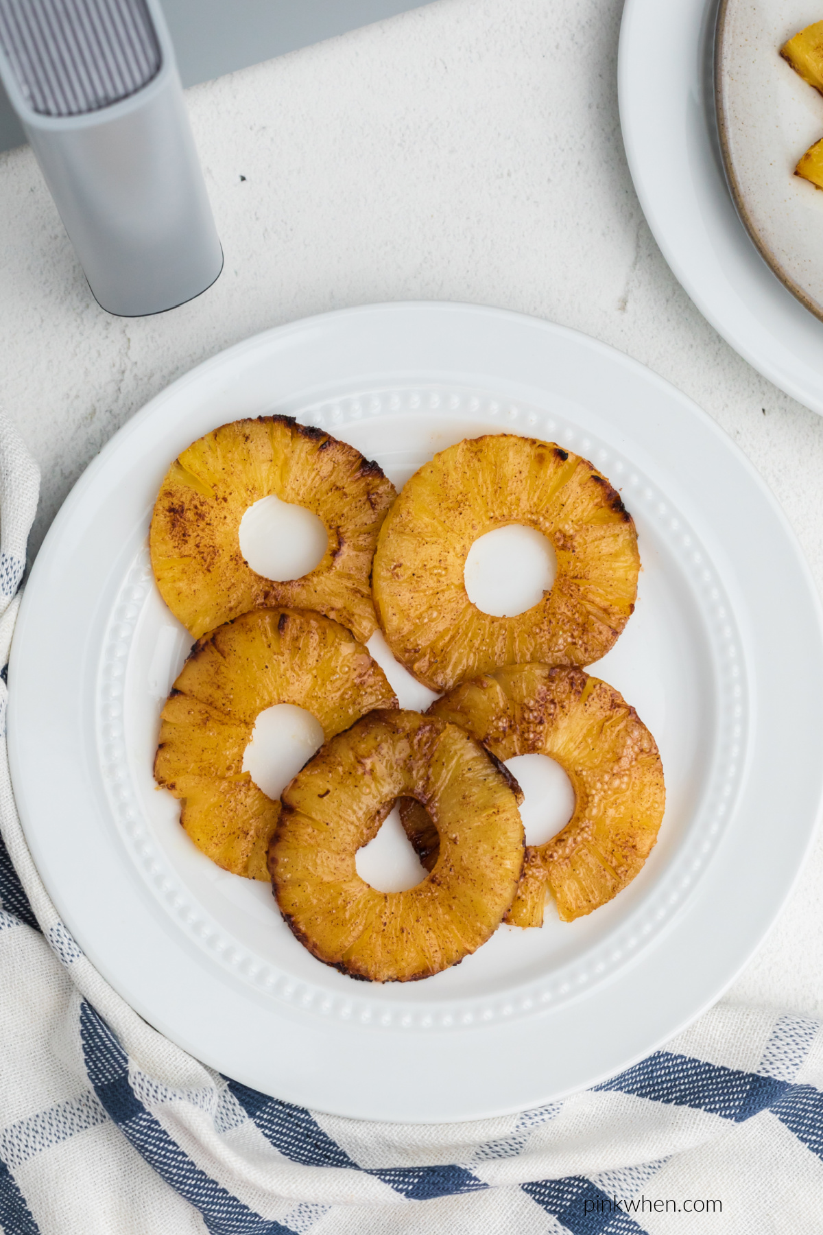 Air fried pineapple rings on a white plate.