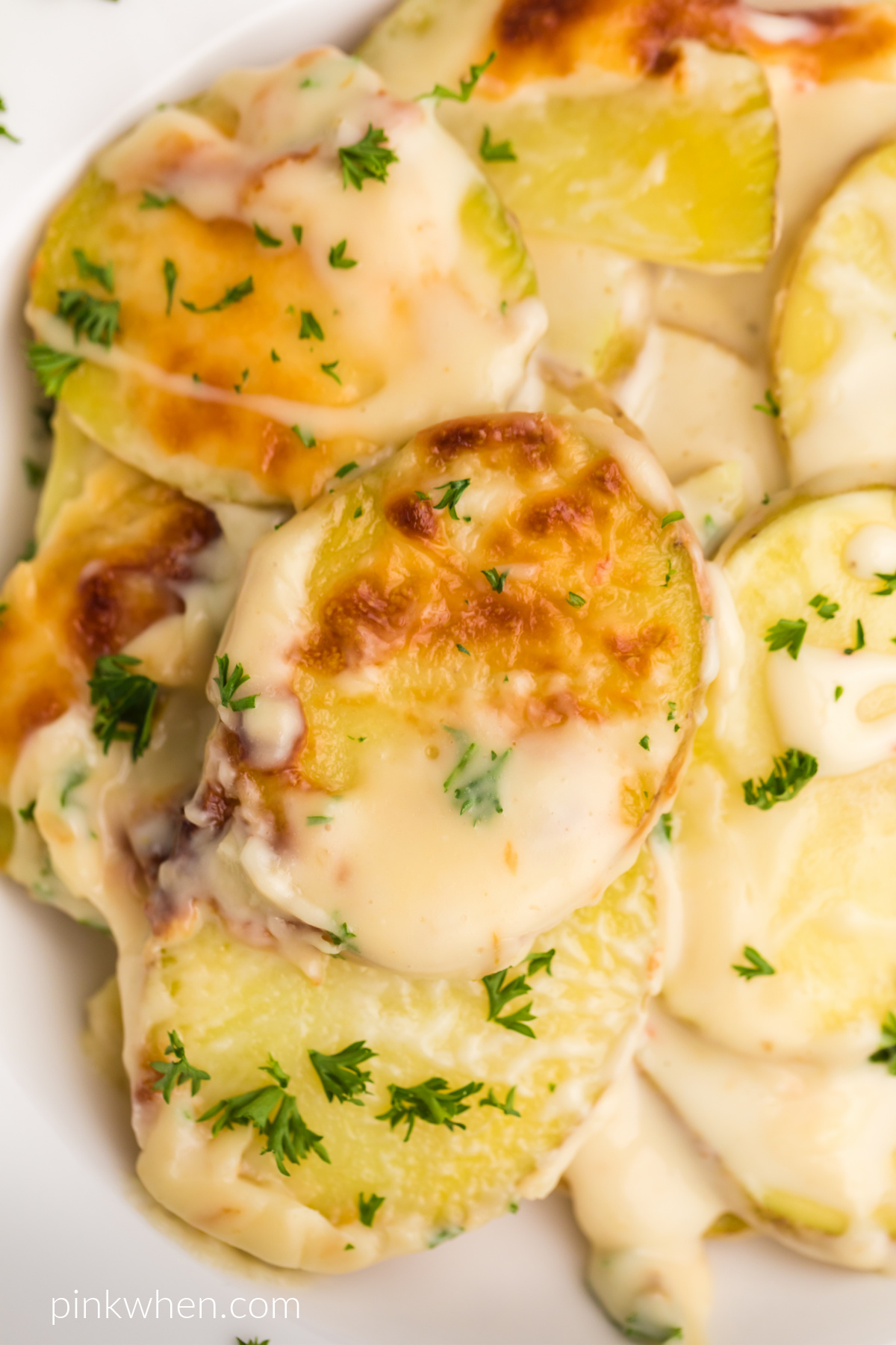 Close up photo of air fryer scalloped potatoes in a bowl. 