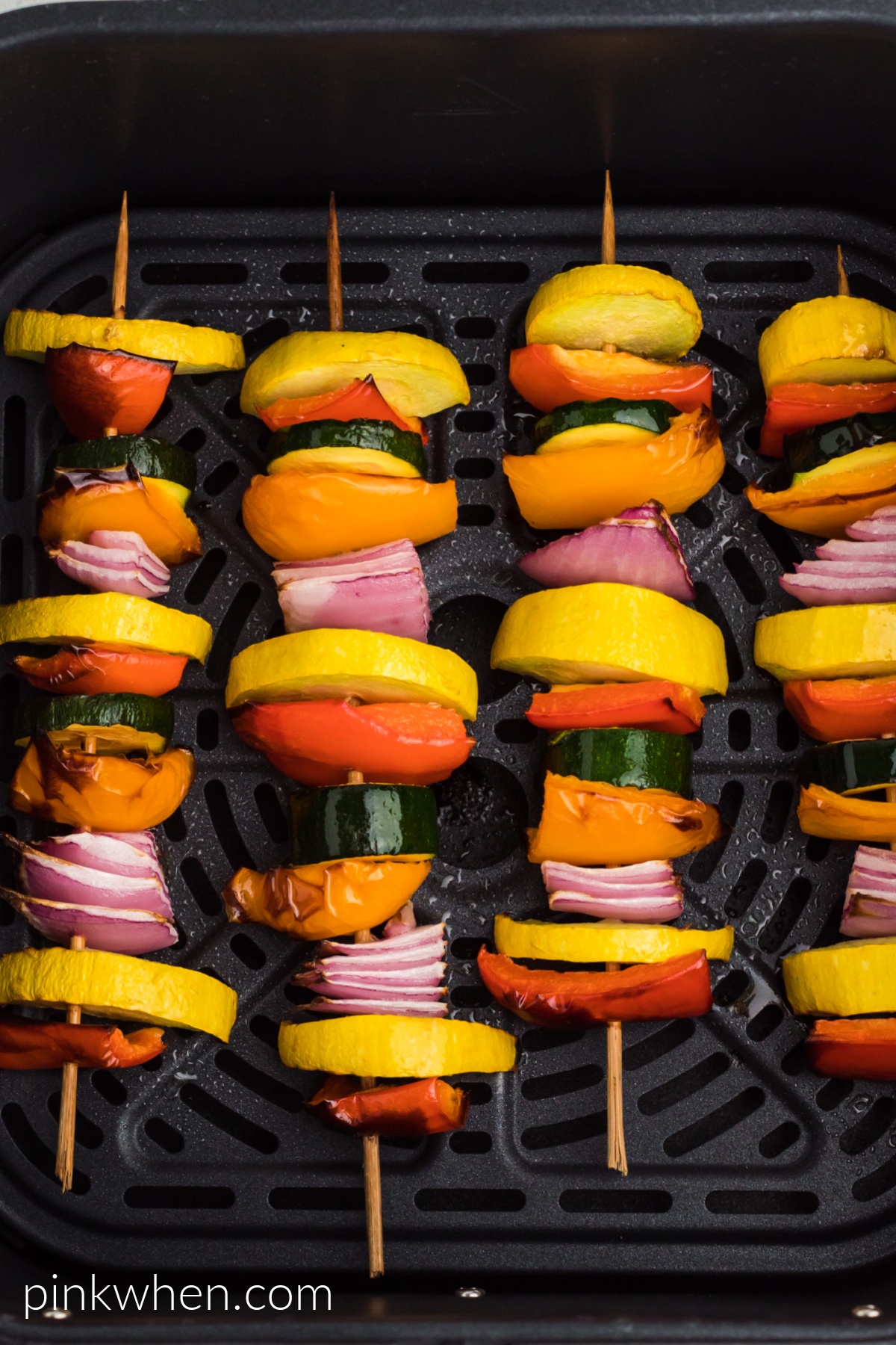 Air fried vegetable skewers in the air fryer basket.