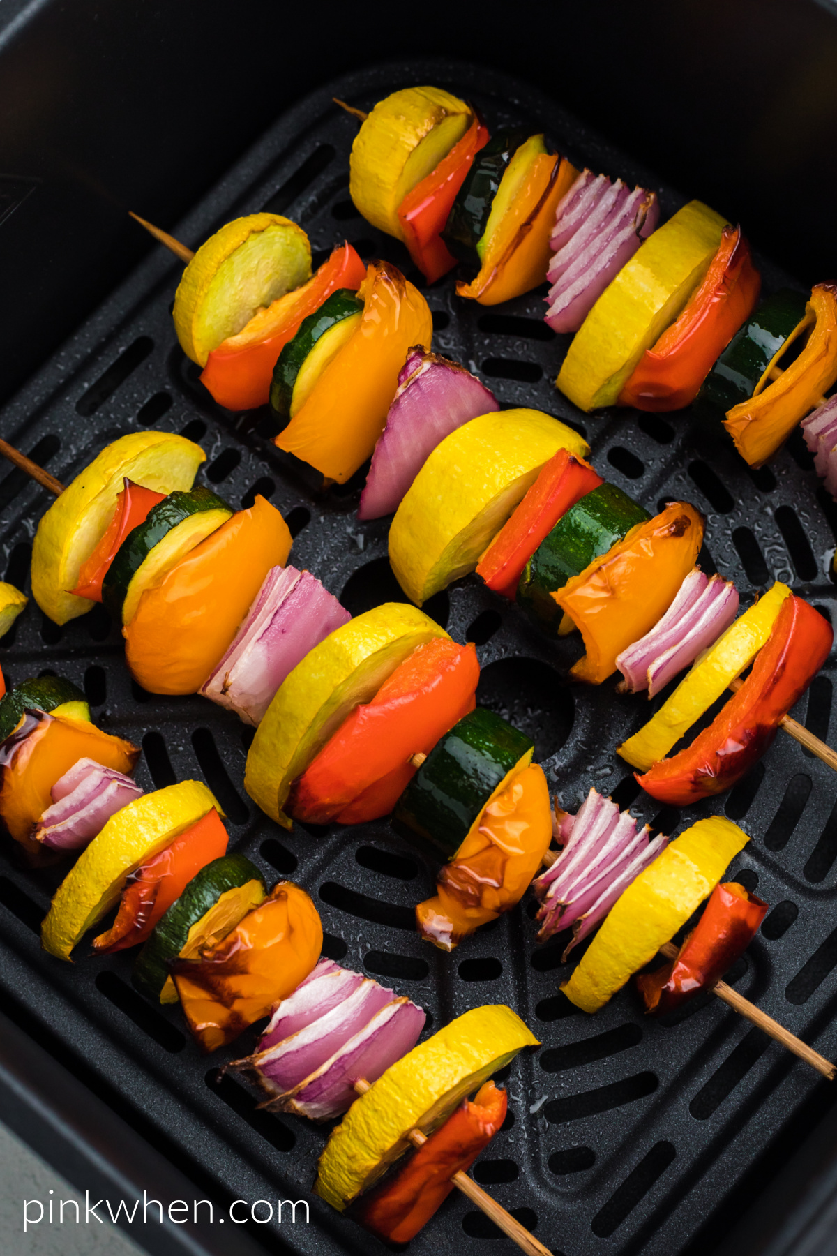 Vegetable kabobs in the air fryer basket, ready to eat.