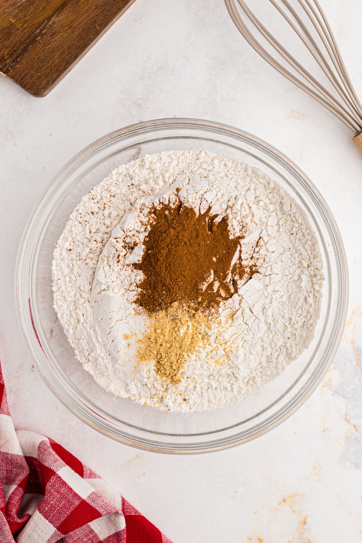 Flour and other seasonings being mixed in a clear glass bowl. 
