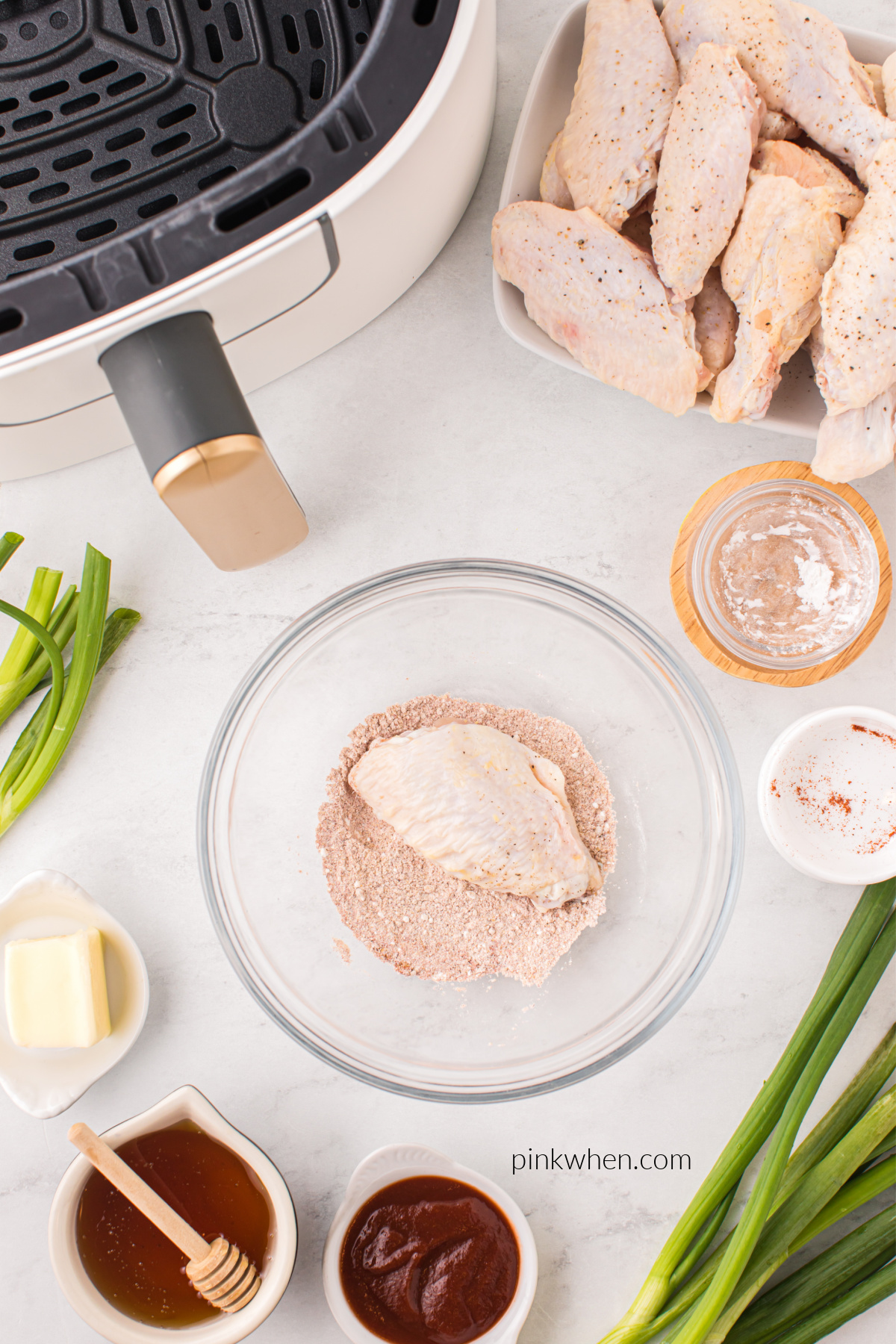 Wing being dipped into the seasoning mixture.