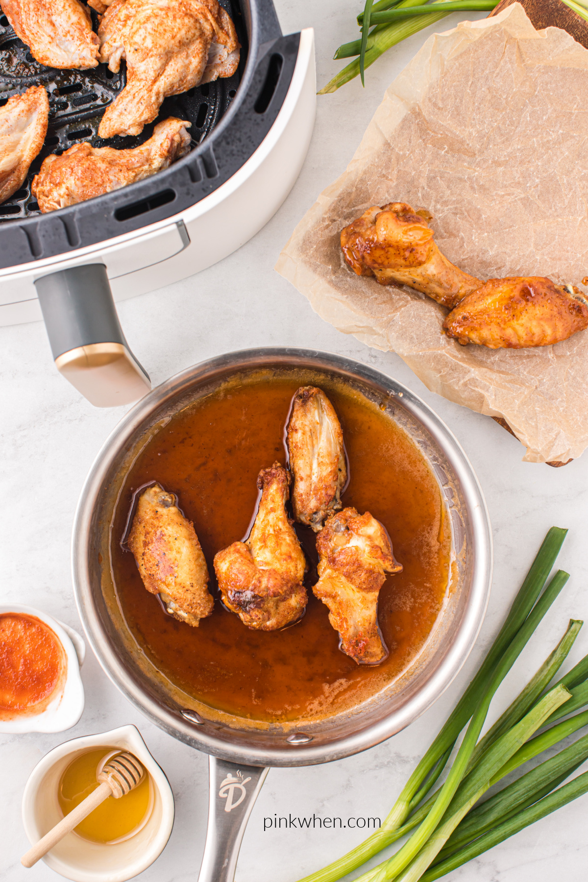 Wings being dipped into the honey sriracha sauce.