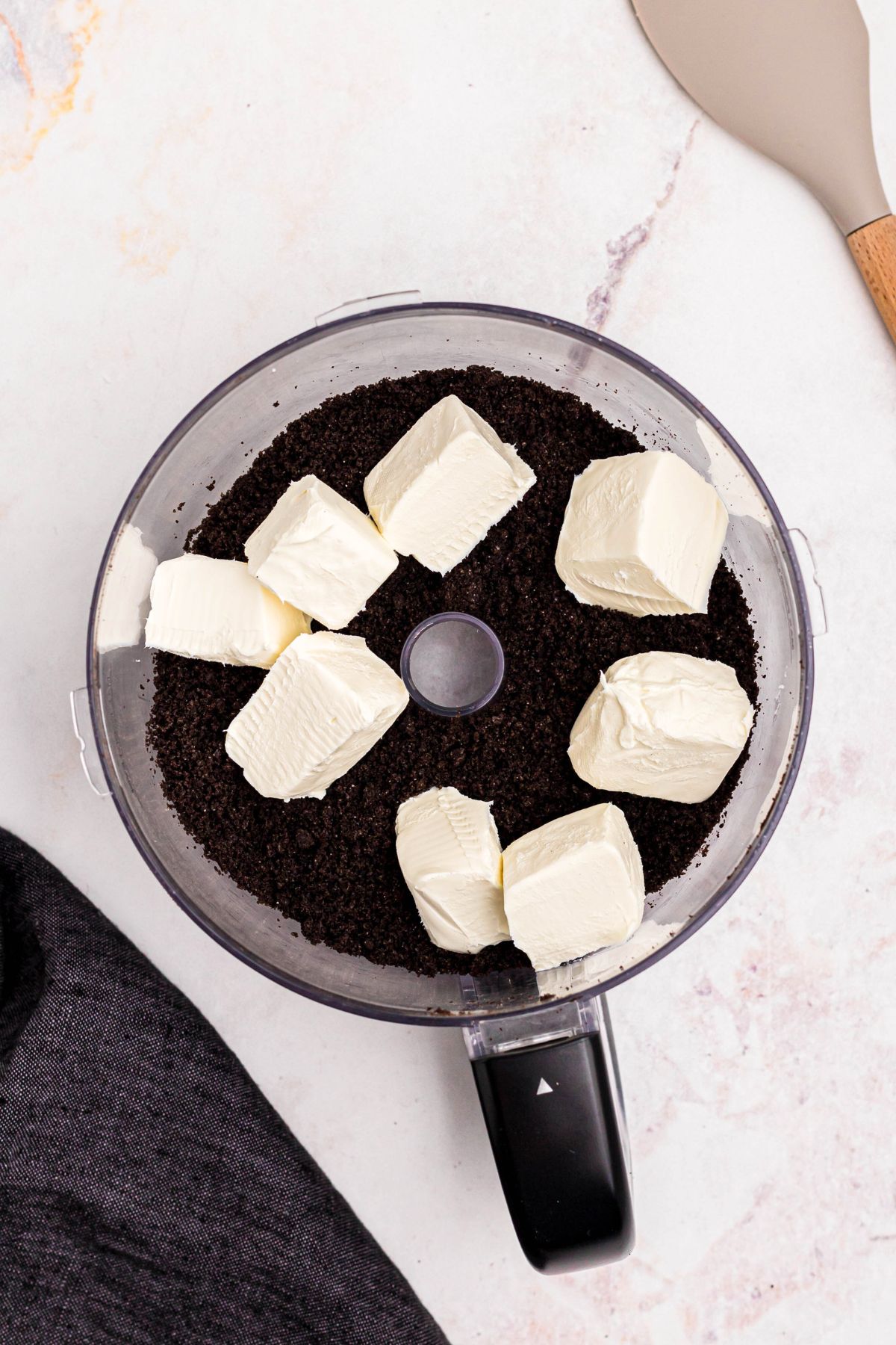Cream cheese cut into pieces added to the food processor with chopped Oreo cookies. 