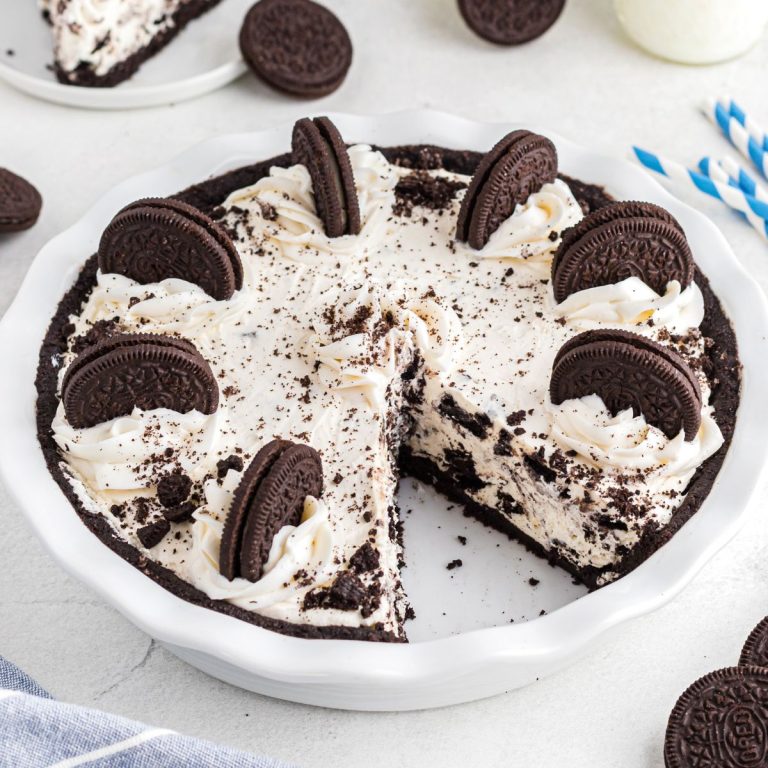 Oreo pie with a slice cut on a white marble table.