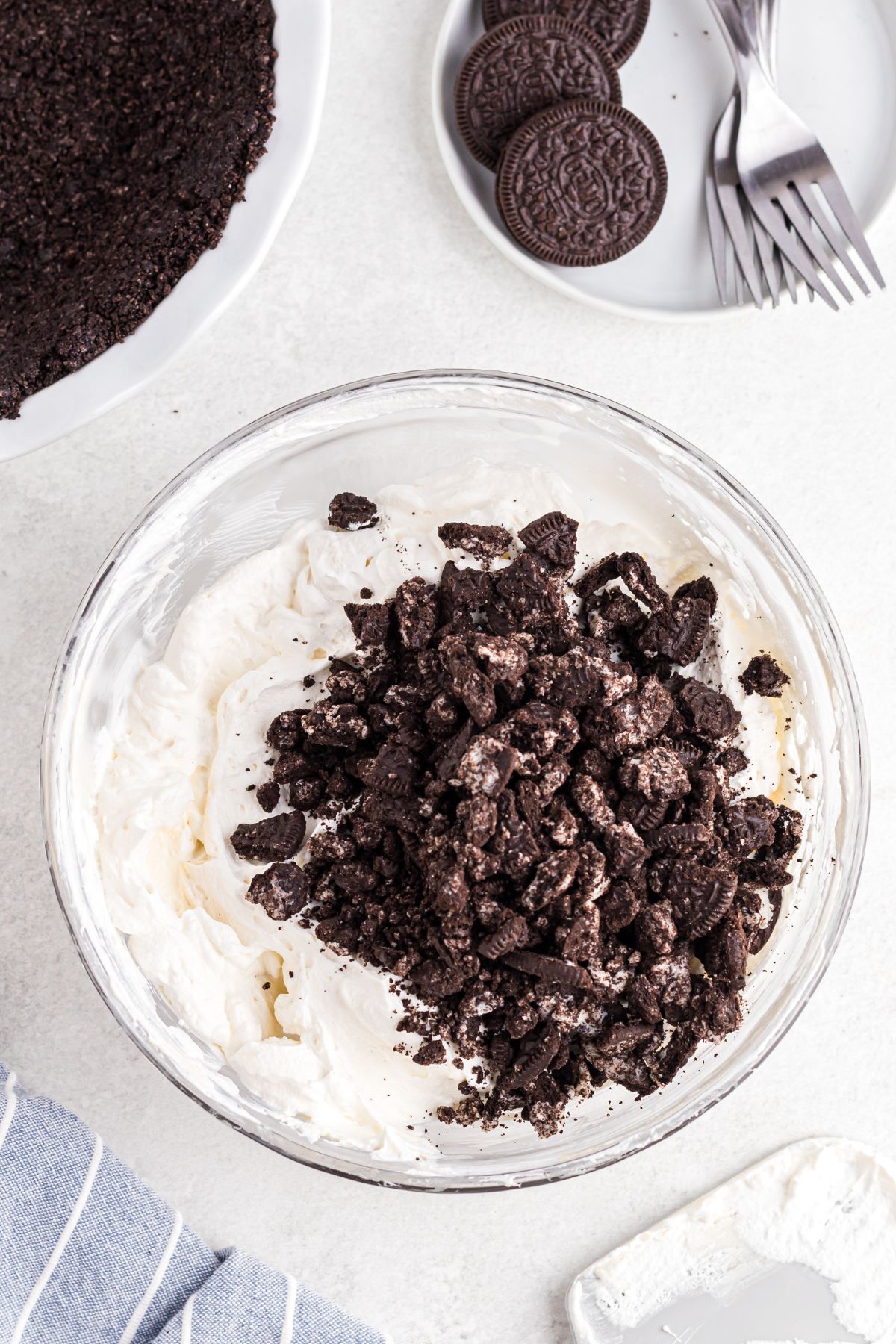 Chopped Oreo pieces being mixed into the pie filling. 