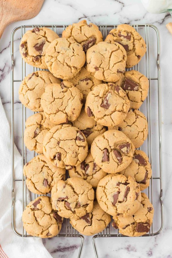 Stacked golden baked peanut butter cookies on a wire rack.