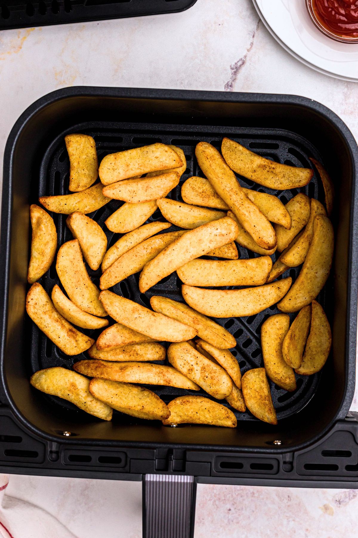 Golden cooked Red Robin steak fries in air fryer basket. 