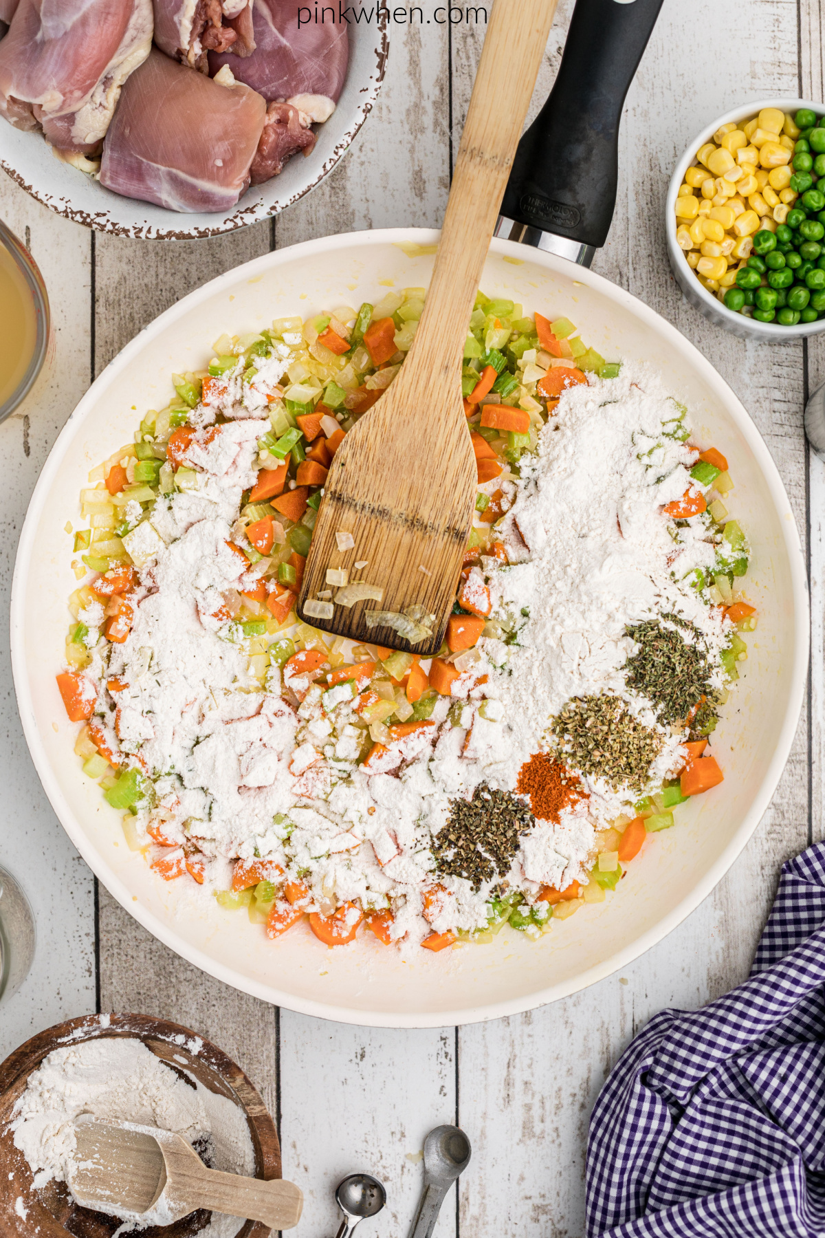 Flour added to vegetables in a skillet.