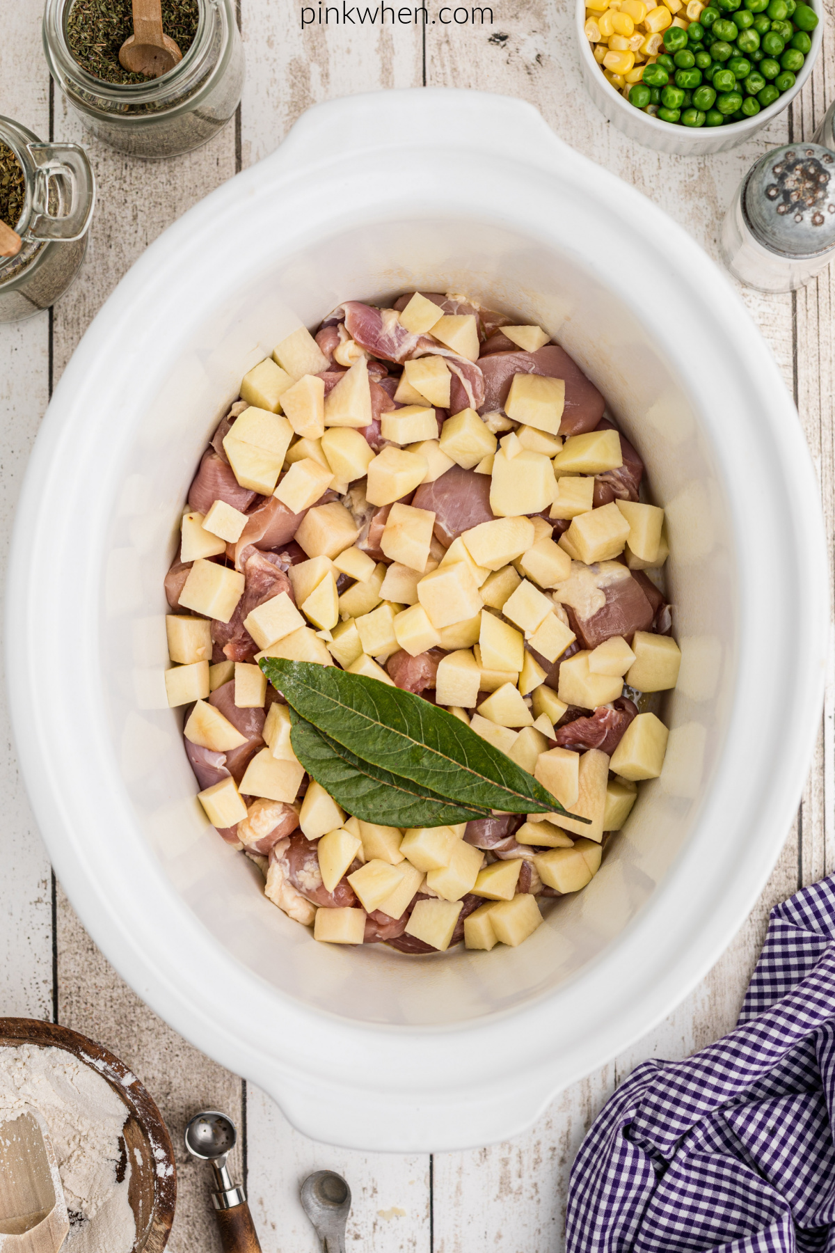 chicken, potatoes, and bay leaves in the slow cooker.