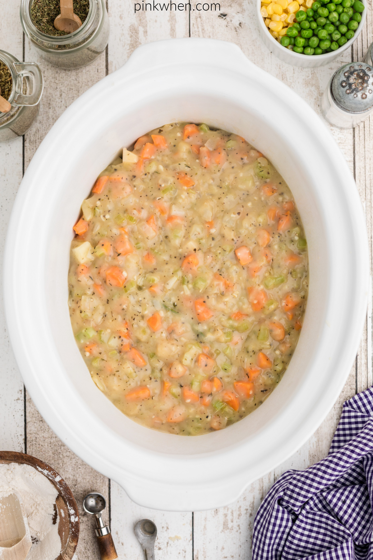 Chicken pot pie vegetable mixture with chicken in the slow cooker.