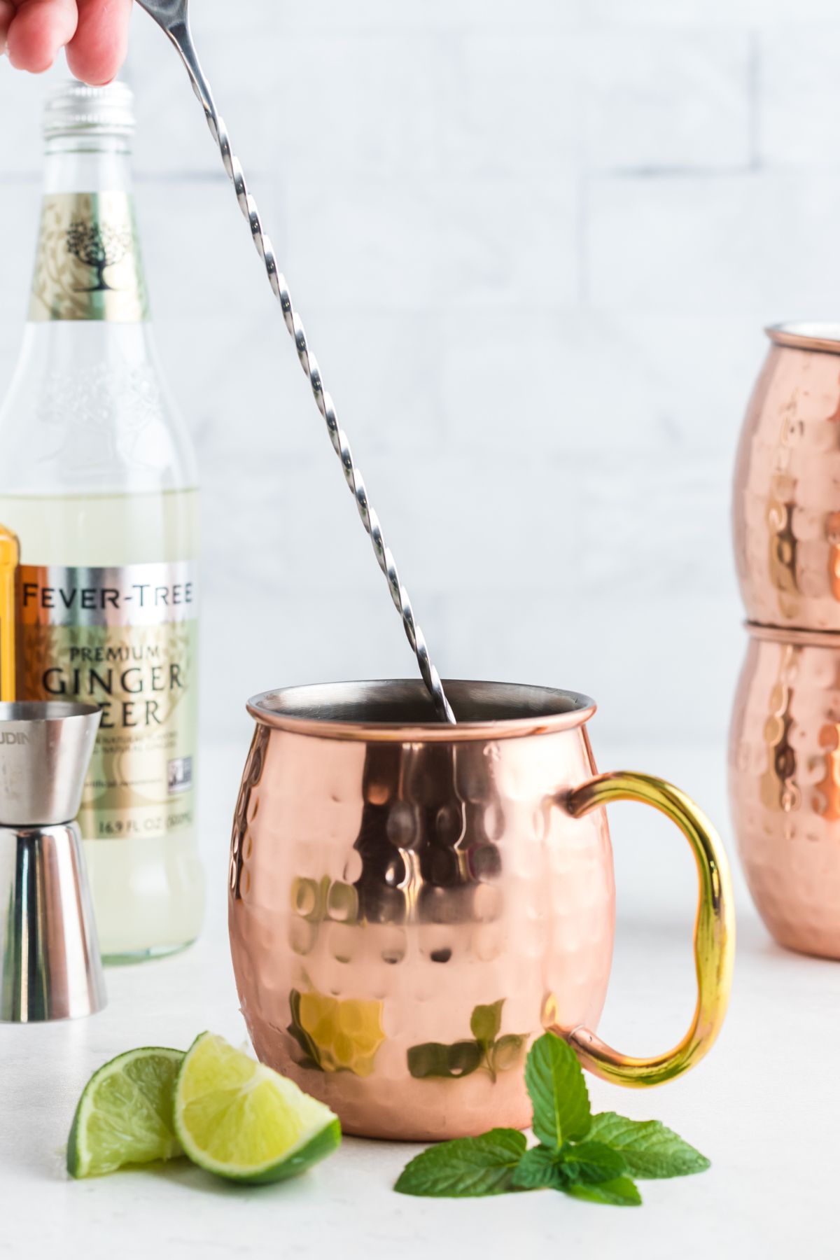 Copper mule mug with ingredients being stirred 