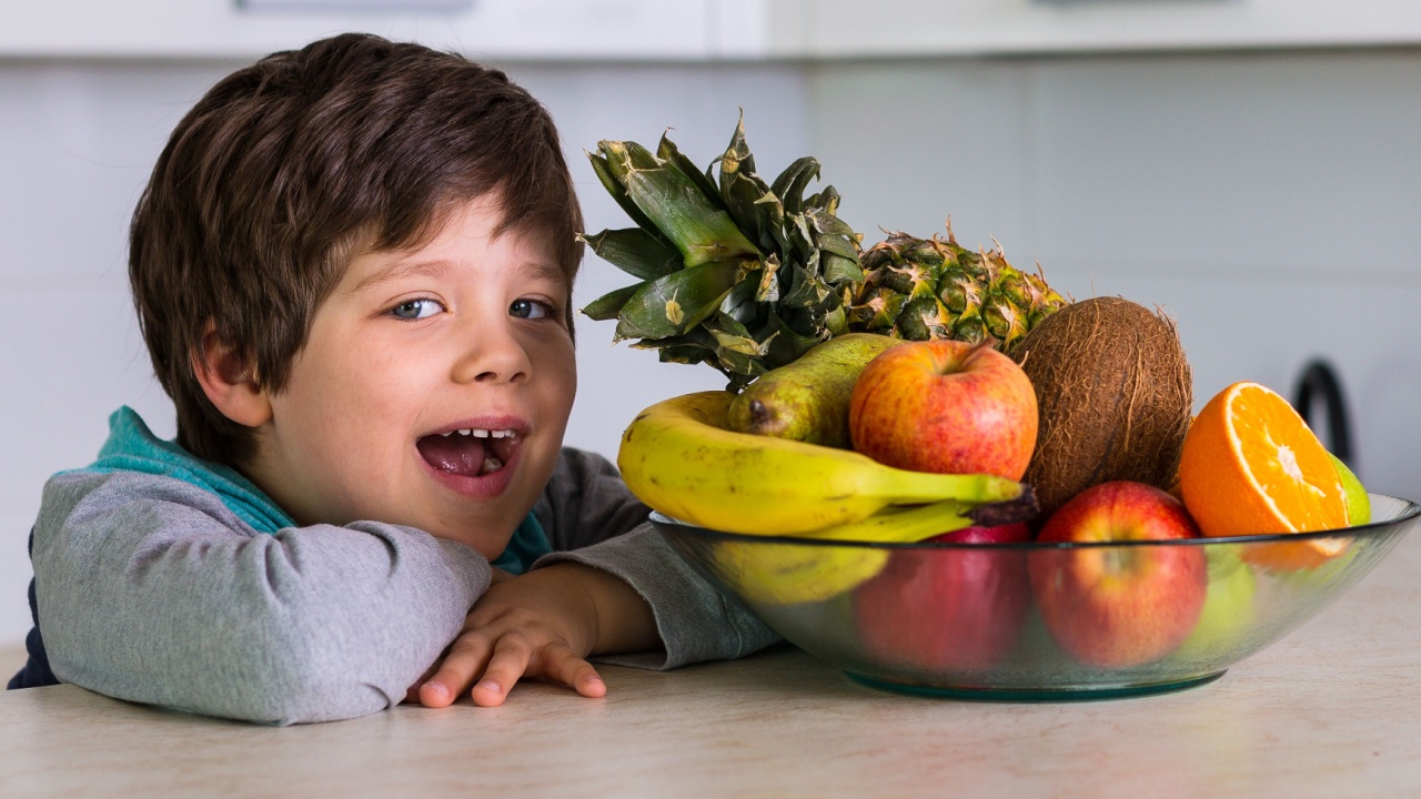 boy in the kitchen with a bowl of fresh fruits