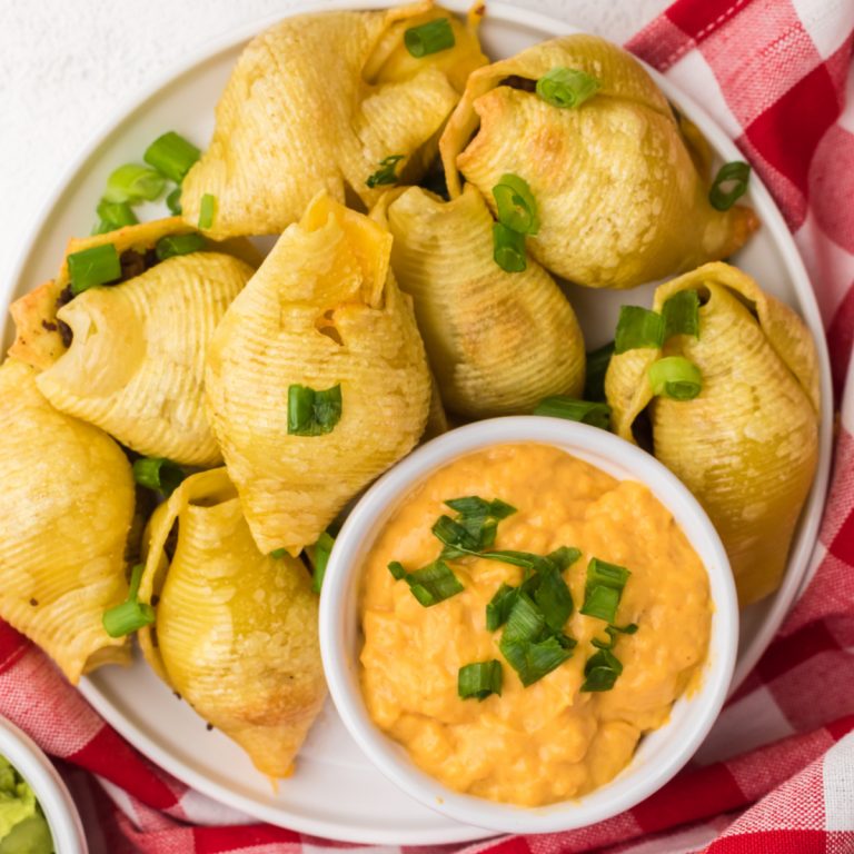 Taco stuffed shells made in the air fryer and served with queso cheese dipping sauce.