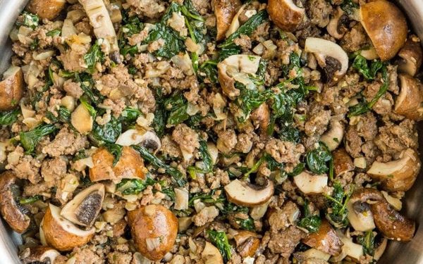 Ground beef and mushrooms in a skillet.