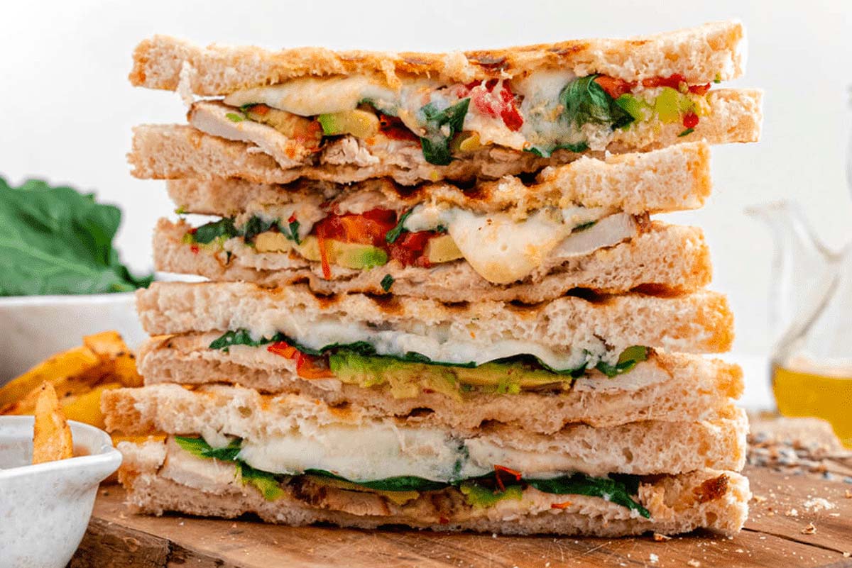 A chicken avocado sandwich cut in half and stacked.