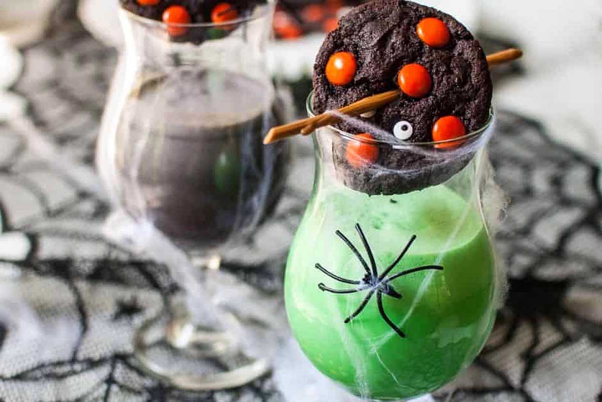 Chocolate Halloween cookie on top of a green drink.