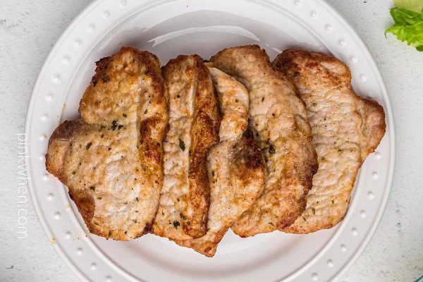 Air fryer pork chops on a white plate.