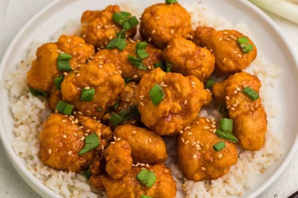 Air Fryer Frozen Orange Chicken served over rice in a white bowl.