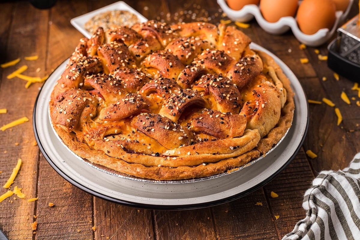 A pie is sitting on a table next to eggs.