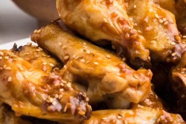 Chicken wings on a plate with sesame seeds.