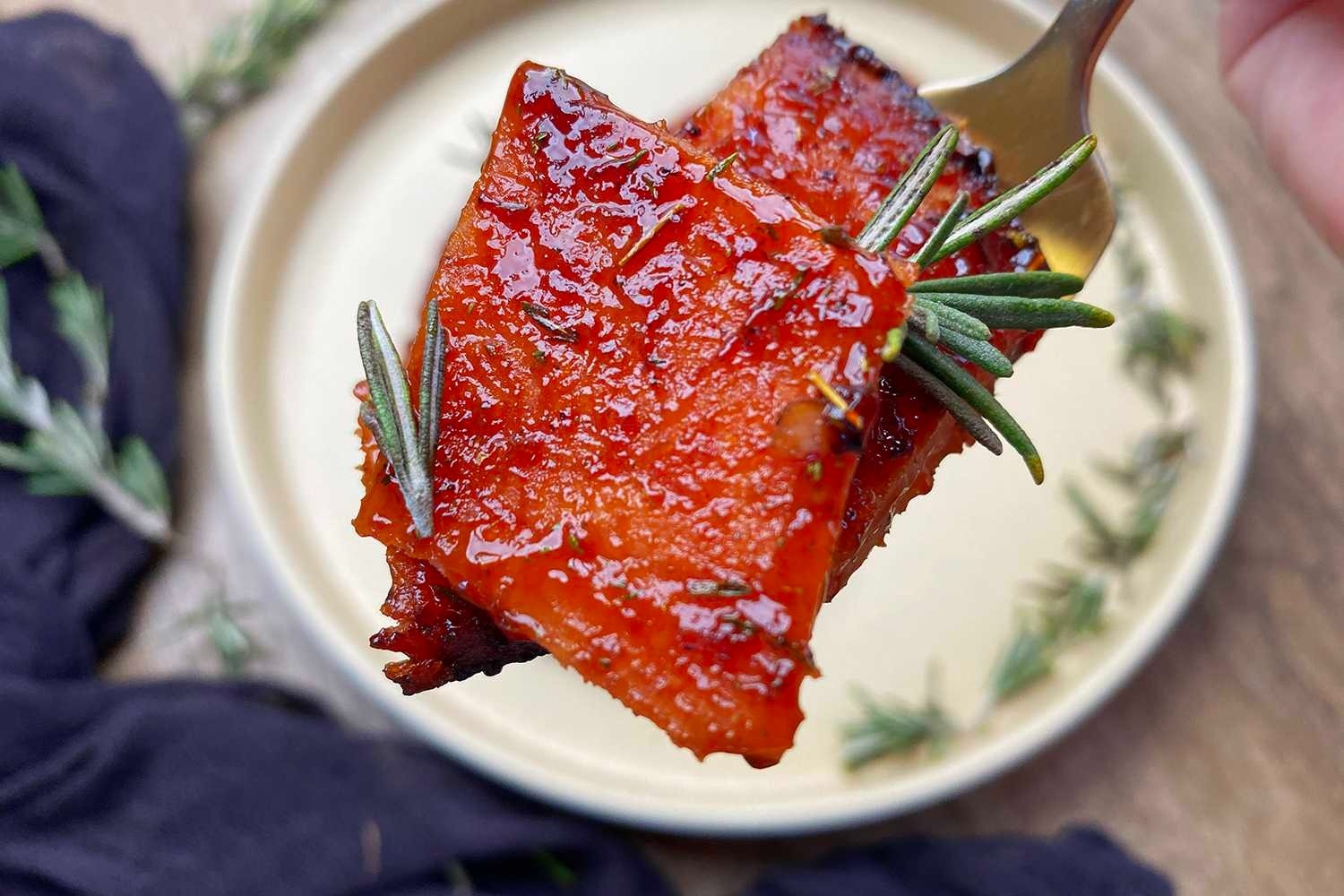 Teriyaki pork chops on a plate with fresh herbs.