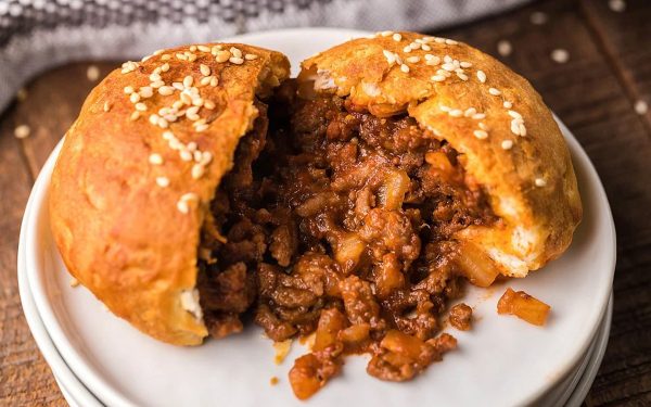 Unsloppy joes on a bun with white plates.
