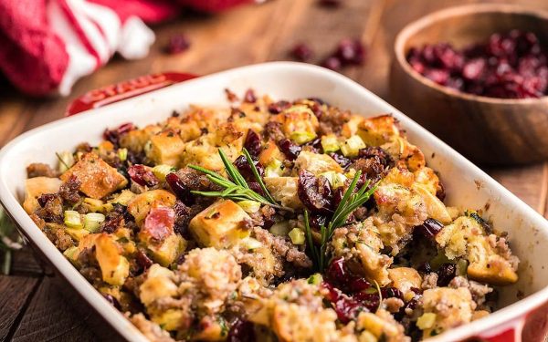 Sausage stuffing with fresh herbs in a casserole dish.