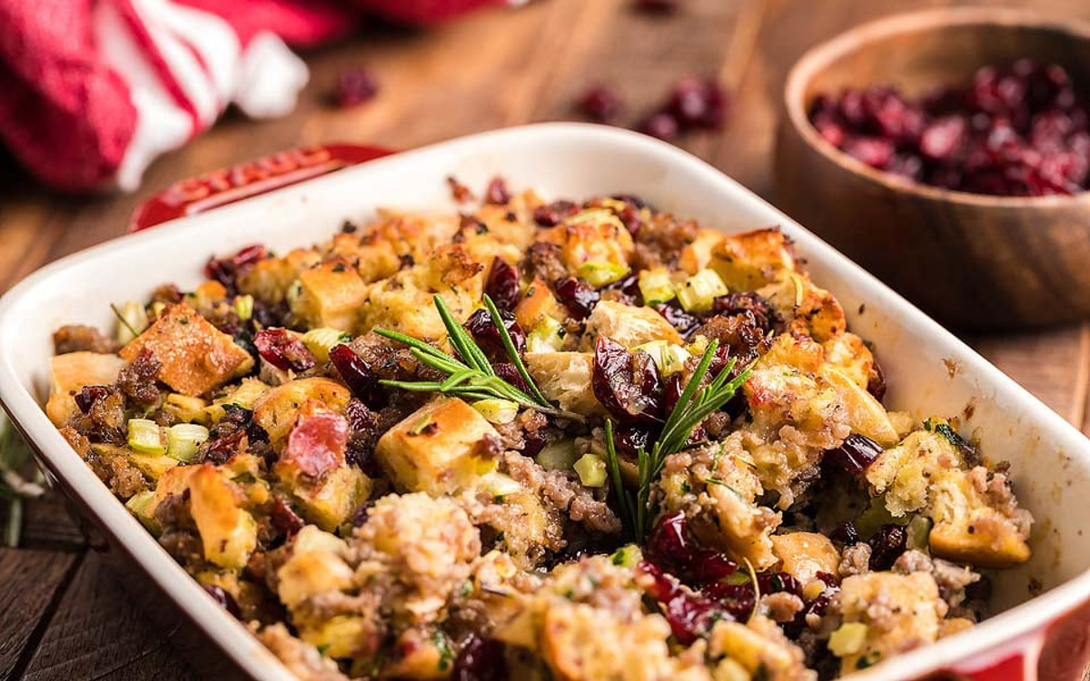 Sausage stuffing with fresh herbs in a casserole dish.