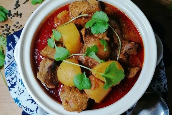 A bowl of stew with meat and potatoes.