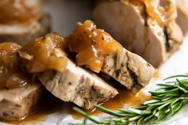 Apple Balsamic Instant Pot Pork Tenderloin on a white plate with rosemary.