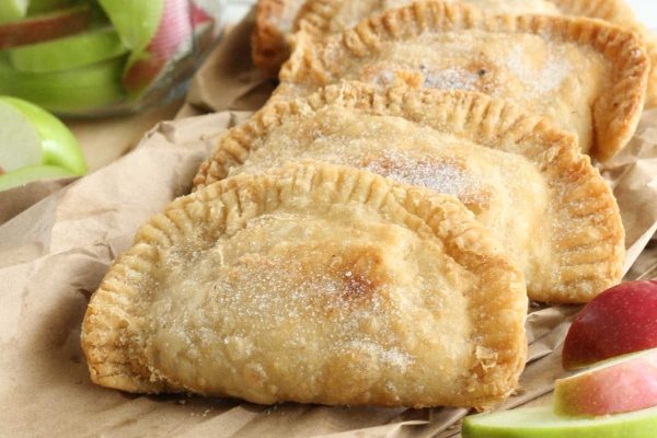 Apple pies on a brown paper bag.