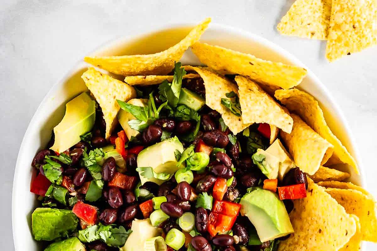 Colorful black bean and avocado salsa served with corn chips.