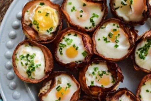 A plate of bacon topped with fried eggs and parsley.