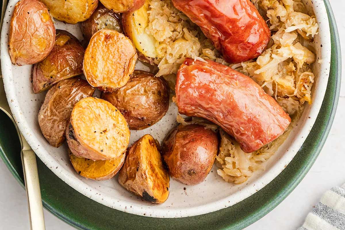 Sauerkraut, potatoes and sausage in a bowl.