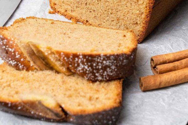 Slices of banana bread with cinnamon sticks.