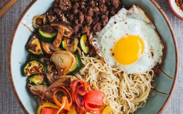 Beef ramen bowl with noodles and fried egg.