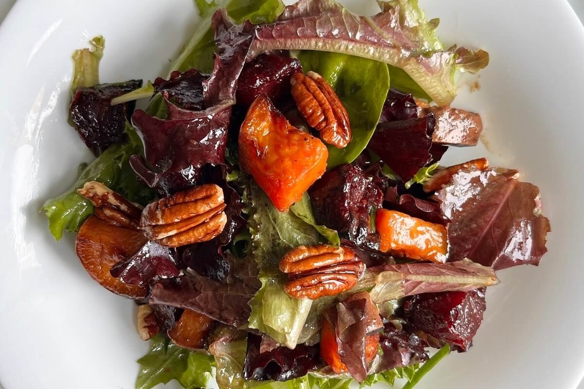 A salad with beets, carrots and pecans.