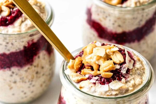 Three jars of overnight oats with berries and nuts.