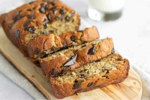 Slices of gluten-free banana bread on a wooden servng board.
