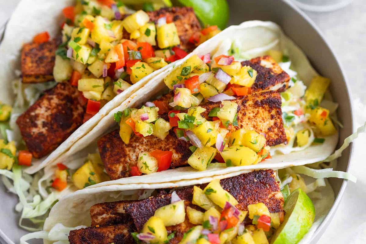 Fish tacos with pineapple salsa on a plate.