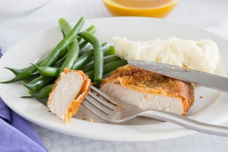 Coated pork chops served with a sauce.